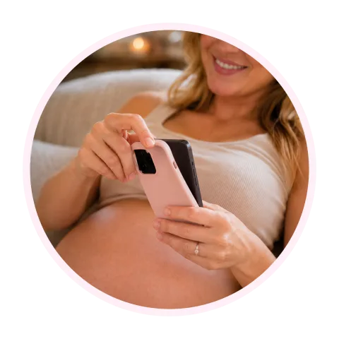 A finger tapping the record button on a phone held against a pregnant belly